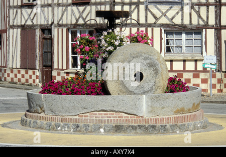Saint Christophe sur Condé - Normandie - France vieille meule utilisée comme décoration rond-point Banque D'Images