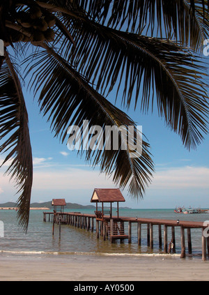 Surplombant des feuilles de palmier, plage, vagues, surf, jetty, brise-lames et des bateaux amarrés dans la distance, Ban Phe, Rayong, Thaïlande Banque D'Images