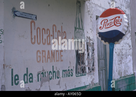 Années 1970 Coca Cola Pepsi Cola publicité. Publicité Mexique panneau de rue en forme de bouchon de bouteille. Murale délavée sur le mur vintage mondialisation publicité 1973 Banque D'Images