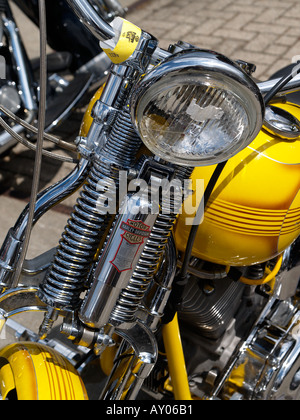 Harley Davidson springer ancien style de suspension avant avec ressorts et amortisseur chromé sur un vélo jaune Banque D'Images