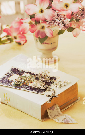 Bible blanc et cristal transparent avec cornouiller rose sur fond jaune. Banque D'Images