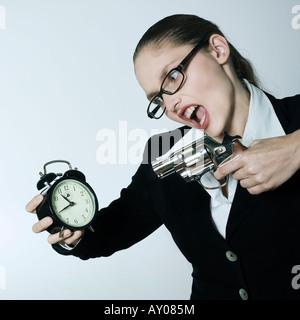 Portrait Portrait d'une belle jeune femme dans un costume tailleur avec des armes d'essayer de tuer le temps Banque D'Images