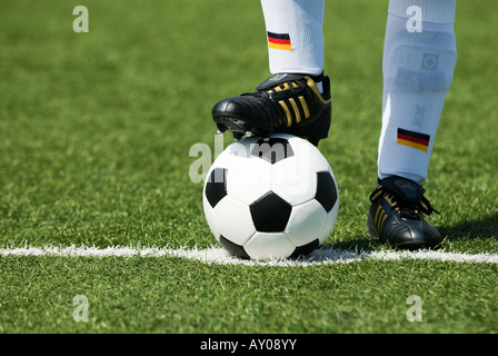 Les pieds d'un joueur de football nationale allemande et d'un football vintage noir et blanc Banque D'Images