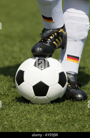 Les pieds d'un joueur de football nationale allemande et d'un football vintage noir et blanc Banque D'Images