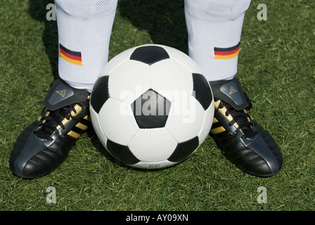 Les pieds d'un joueur de football nationale allemande et d'un football vintage noir et blanc Banque D'Images