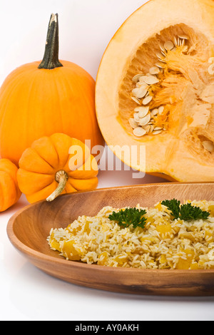 Un risotto préparé avec de la citrouille comestible rôtie avec une décoration de citrouilles orange entières personne au-dessus des photos verticales colorées aux États-Unis Banque D'Images