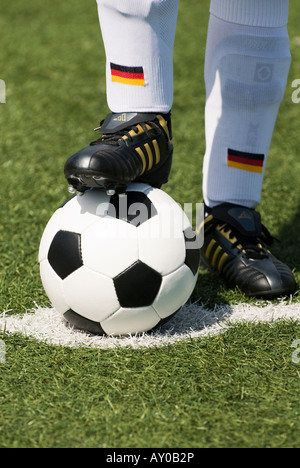 Les pieds d'un joueur de football nationale allemande et d'un football vintage noir et blanc Banque D'Images