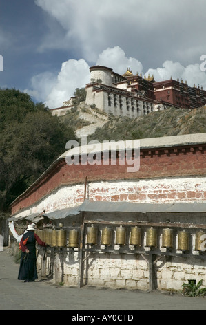 Pilgrim tourne la roue de prière à l'extérieur du palais du Potala, Lhassa, dans la région autonome du Tibet, Chine. Septembre 2006. Banque D'Images