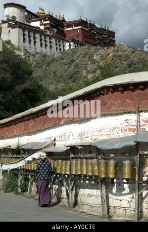 Pilgrim tourne la roue de prière à l'extérieur du palais du Potala, Lhassa, dans la région autonome du Tibet, Chine. Septembre 2006. Banque D'Images