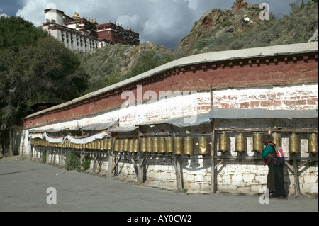 Une femme en costume traditionnel pèlerinage tourne roues de prière à l'extérieur du palais du Potala, Lhassa, dans la région autonome du Tibet, Chine. Sept. Banque D'Images