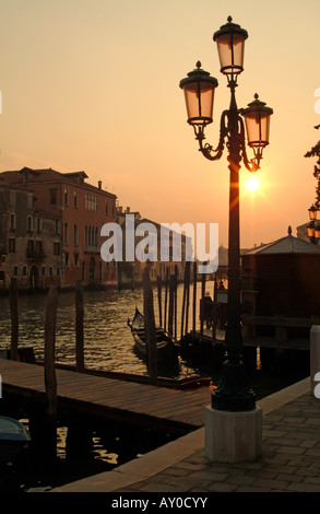 Côté gondoles amarré à l'ampoule traditionnelle poster au coucher du soleil sur le Grand Canal, Venise, Italie Banque D'Images