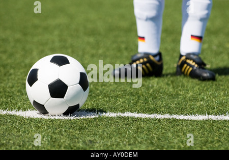 Les pieds d'un joueur de football nationale allemande et d'un football vintage noir et blanc Banque D'Images