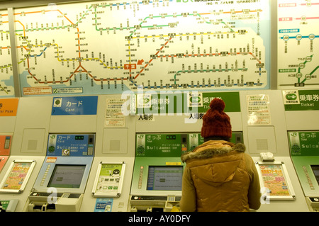 Femme acheter un billet de métro à Tokyo, Japon Banque D'Images