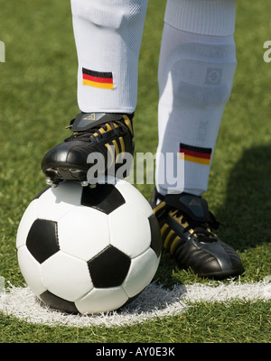 Les pieds d'un joueur de football nationale allemande et d'un football vintage noir et blanc Banque D'Images