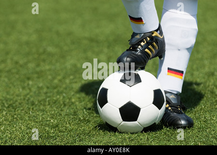 Les pieds d'un joueur de football nationale allemande et d'un football vintage noir et blanc Banque D'Images