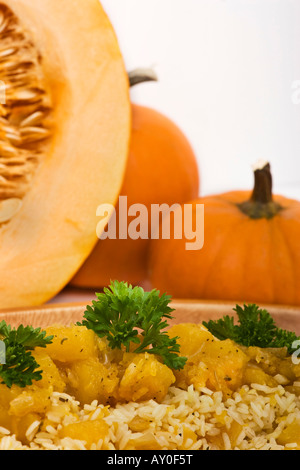 Un risotto préparé avec de la citrouille comestible rôtie avec une décoration de citrouilles orange entières personne au-dessus de la verticale aux États-Unis haute résolution Banque D'Images