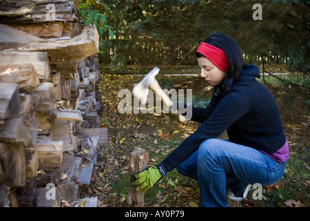 Jeune femme coupe bois de chauffage Banque D'Images