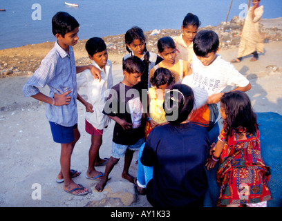 Les enfants de la communauté à un autochtone Kohli plein air impromptu de la classe d'étude dans leur village Worli Koliwada Mumbai Inde Banque D'Images