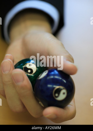 Close-up of a man's hand holding deux billes sur symbole Yin Yang Banque D'Images