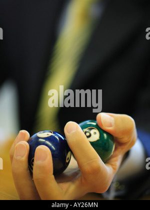 Close-up of a man's hand holding deux billes sur symbole Yin Yang Banque D'Images