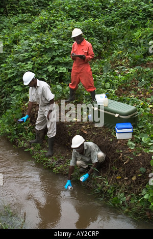 Prendre des échantillons d'eau de rivière pour la qualité de l'essai sur l'exploitation minière industrielle complexe, Ghana Banque D'Images