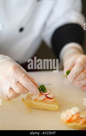 Chef de la préparation d'un mini-sandwiches aux crevettes Banque D'Images