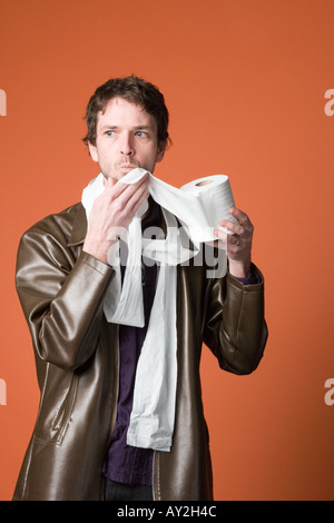 Young Caucasian man enveloppé dans du papier de toilette Banque D'Images