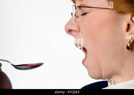 Femme avec une cuillère de dégustation bad medicine Banque D'Images