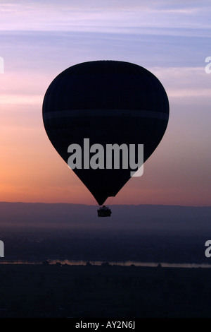 Ballon à air chaud qui se profile en face de magnifique coucher de soleil sur le Nil [près de Louxor, Egypte, Etats arabes, l'Afrique]. . Banque D'Images