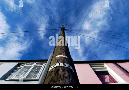 Un poteau télégraphique avec un site web de lignes rayonnant à partir de son sommet se tient devant une terrasse de maisons victoriennes à Brighton Banque D'Images