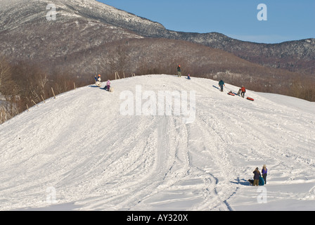 Les familles avec des tubes de neige sur la colline de la luge sur un après-midi d'hiver s sous les montagnes Vertes du Vermont dans Underhill Banque D'Images