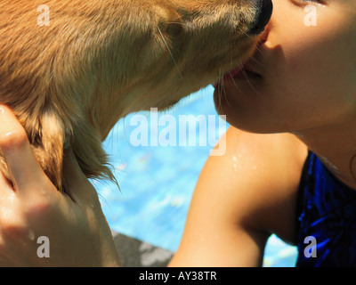 Close-up of a young woman kissing un golden retriever Banque D'Images
