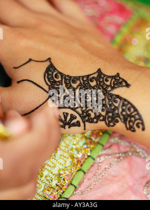 Close-up of a woman's hand l'application de tatouage au henné sur une autre femme. Banque D'Images