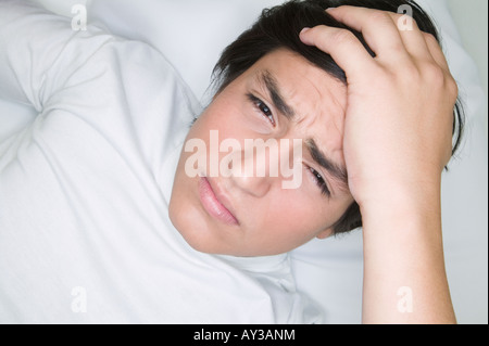 Young Hispanic man with hand on head Banque D'Images