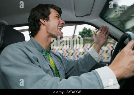 Hispanic man yelling au volant Banque D'Images