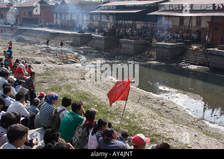 Les membres du parti communiste de démontrer au cours de la crémation de leur chef de parti à la Banque de la rivière Bagmati au Népal Banque D'Images