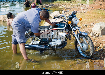 Man une moto dans une rivière, Madurai, Tamil Nadu, Inde Banque D'Images