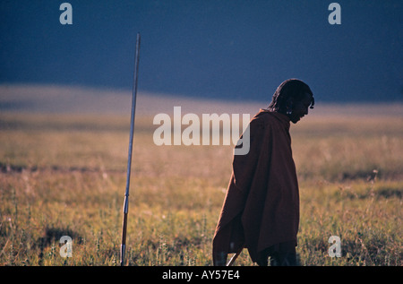 Une tribu masaï est une figure solitaire sur une plaine de la Tanzanie au coucher du soleil Banque D'Images