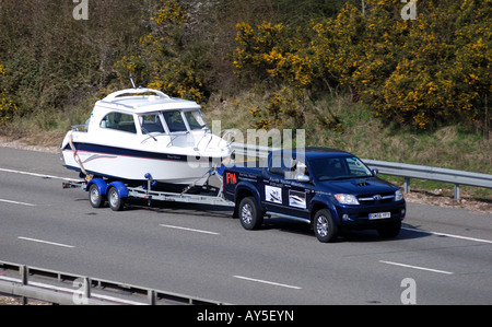 Le remorquage du véhicule quatre roues motrices cabin cruiser sur l'autoroute M40, UK Banque D'Images
