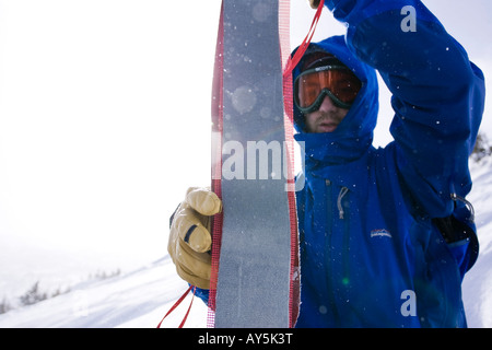 L'homme dépose son skieur peaux de ses skis Banque D'Images