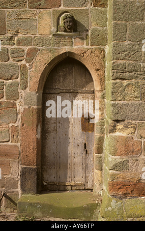 Porte en chêne sculpté avec stone face au-dessus, l'église All Saints, Lapley, Staffordshire, Angleterre Banque D'Images