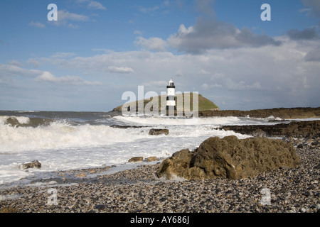 Penmon Point Ile d'Anglesey au nord du Pays de Galles UK Mars Les vagues se briser sur la plage et le phare de la colonne Banque D'Images