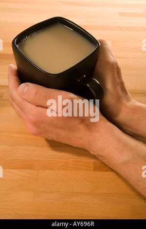 Réchauffement de l'homme ses mains autour d'une tasse de café Banque D'Images