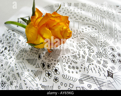 Rose fanée sur note papier rempli de doodles Banque D'Images
