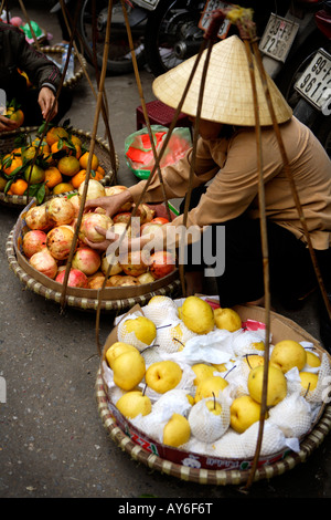 Vendeur de rue femme vendant des fruits, à l'extérieur du marché Dong Xuan, vieux quartier, Hanoi, Vietnam Banque D'Images