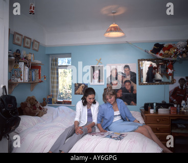 Les adolescentes dans la chambre,la lecture de revues et de chat, Ascot, Berkshire, Angleterre, Royaume-Uni Banque D'Images