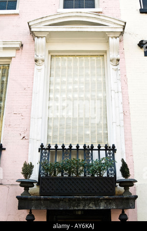 Immeuble urbain peint en rose et blanc avec les caractéristiques architecturales et balcon Jardin fort Banque D'Images