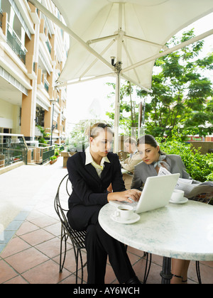 Businesswomen having discussion assis à table de café à l'extérieur Banque D'Images