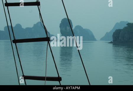 La baie d'Halong est habituellement photographiés en plein soleil avec ciel bleu. Cette image a été prise lorsque la nuit avait rempli la baie avec une étrange lumière bleue. Banque D'Images