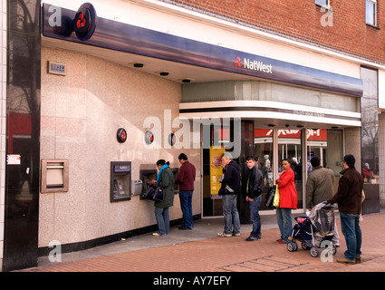 Les clients en file d'utiliser Nat West Bank machines distributeur, High Street, Hounslow, Middlesex, Royaume-Uni. Banque D'Images